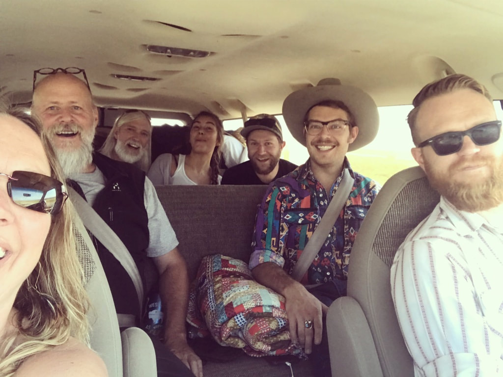 The whole band in the van, traveling through Wyoming.